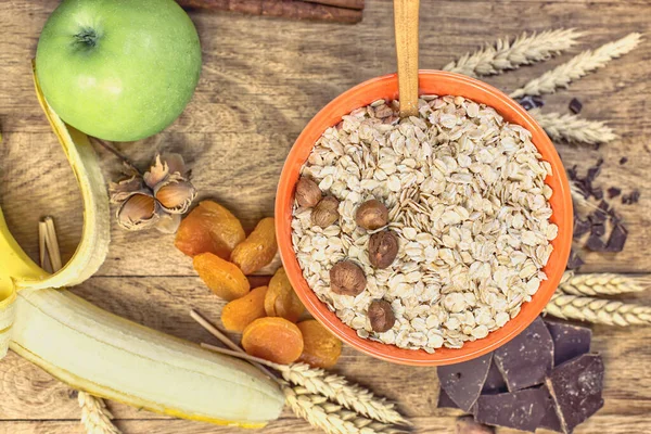 Yulaf gevreği, fındık ve meyve sağlıklı beslenme, sade ahşap masada sağlıklı vejetaryen kahvaltısı