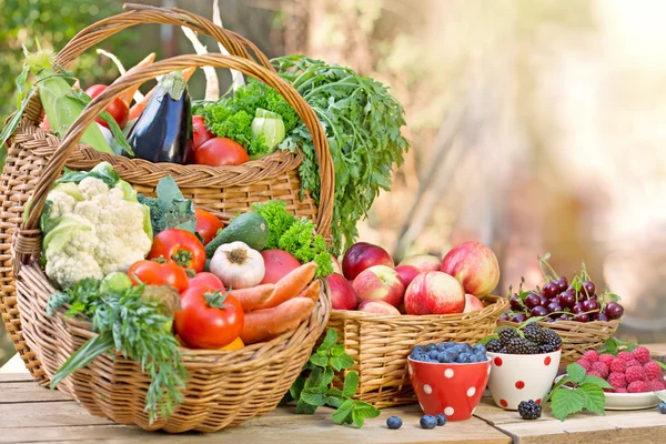 Organic fruits and vegetables in wicker baskets — Stock Photo, Image