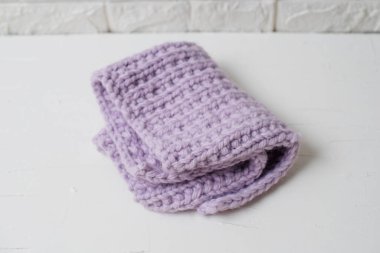 Beyaz arka planda ev konforu üzerine eflatun örülmüş el yapımı battaniye.