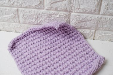 Beyaz arka planda ev konforu üzerine eflatun örülmüş el yapımı battaniye.