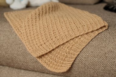 Ev içinde bej örülmüş el yapımı battaniye.