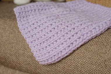 Ev içinde eflatun örülmüş el yapımı battaniye.