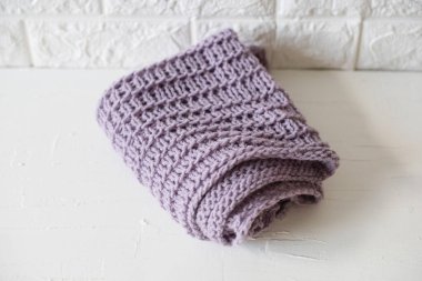 Yumuşak örülmüş eflatun desenli, kumaşlı, beyaz bir masa üzerinde yaratıcı desenli bir ekose.