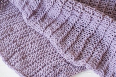 Yumuşak örülmüş eflatun desenli, kumaşlı, beyaz bir masa üzerinde yaratıcı desenli bir ekose.