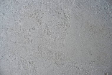 Dekoratif sıva arkaplanı, pürüzlü kenarlı pürüzlü kum, gri beyaz kirli renk.