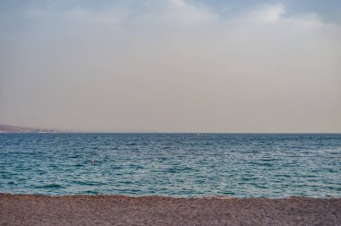 Eilat denizindeki kumsal Mavi gökyüzü günbatımı tatilinin keyfini çıkarın.