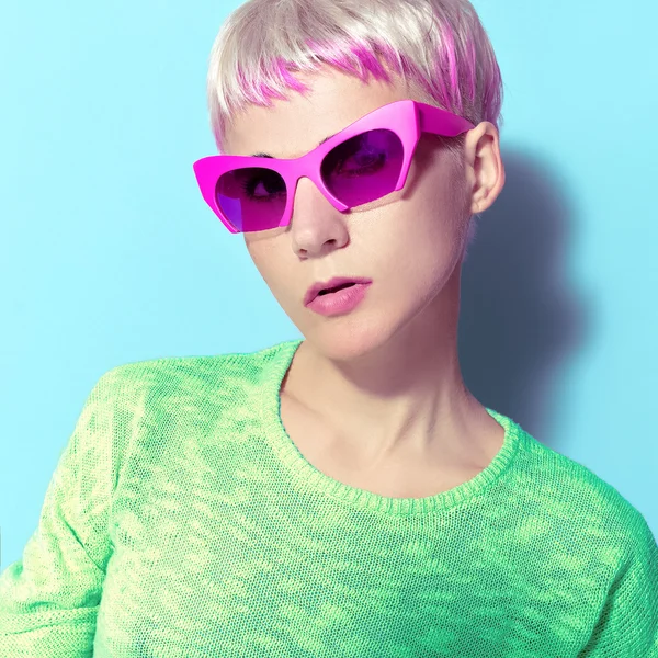 Blonde with a fashionable hairstyle and pink glasses. — Stock Photo, Image