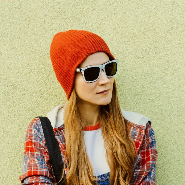 Chica en lugares urbanos en sombrero rojo y gafas de sol de moda . — Foto de Stock