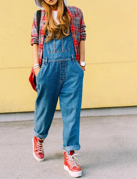 Urban Fashion stijl meisje. Geruite hemd en denim Amerikaanse overalls. — Stockfoto