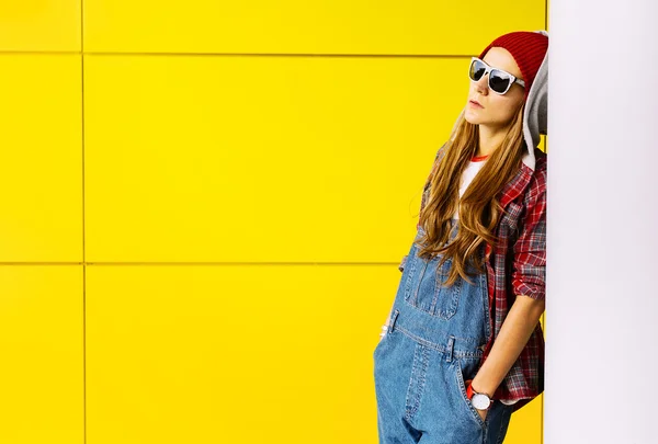 Stylish Brunette standing at the yellow wall. Autumn fashion sty — Stock Photo, Image