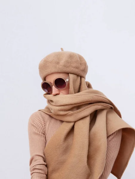 Stylish Details of everyday look.  Model wearing casual beige outfit.  Beret  and scarf. Trendy sunglasses. Minimalistic style. Total Beige aesthetics. Fashion look book. Warm Fall Winter seasons concept