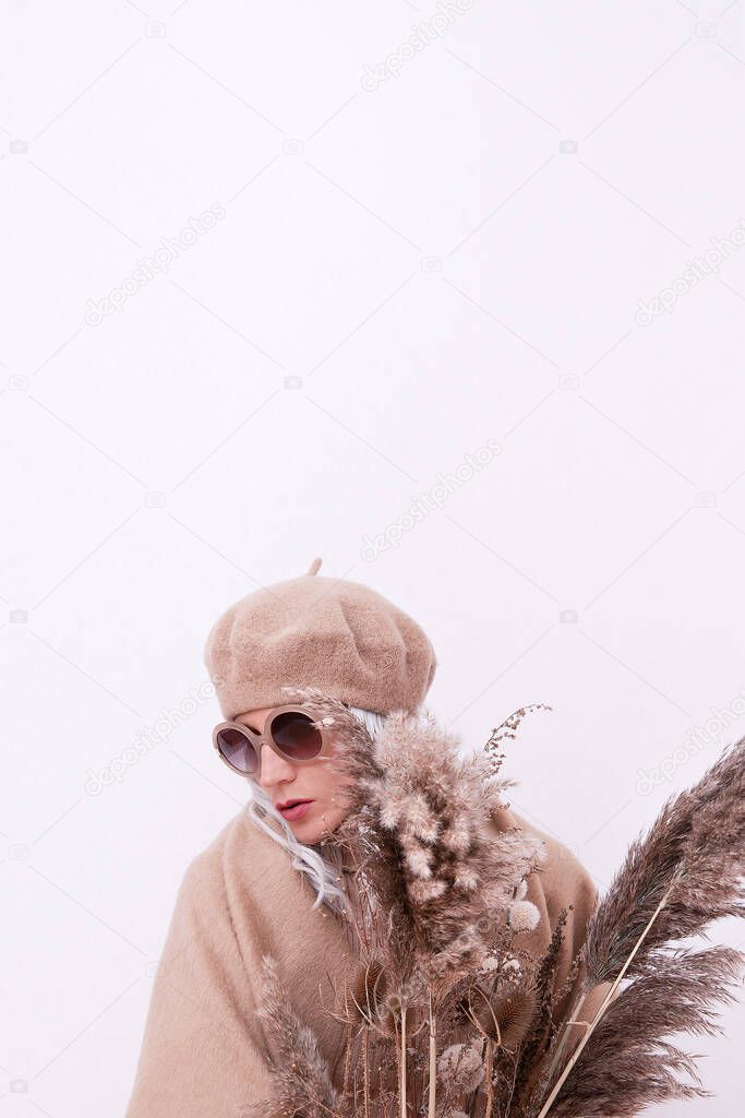Blonde model wear casual beige outfit. Stylish beret, sunglasses and scarf. Winter, fall autumn or spring clothing. Comfort and warm. Minimal total beige aesthetic