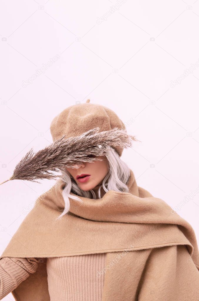 Sensual blonde Lady with autumn flowers. Stylish Details of everyday look. Model wearing casual beige outfit. Beret and scarf. Trendy minimalistic style. Total Beige aesthetics. Fashion look book. Warm Fall Winter seasons
