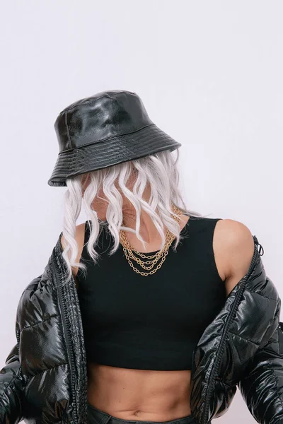 Sexy blonde model in fashion urban street outfit. Trendy black bucket hat and bomber. Daring Jewelry  Stylish Fall winter seasons. Rap hip hop vibes