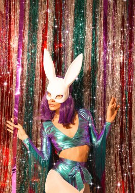 Disko kızı 80 'lerin modaya uygun holografik parti görüntüsü ve tavşan maskesi. Tinsel kurulum. Yeni yılın kulüp konsepti. Mutlu noeller. Tatil günü. Yıldızlar gibi moda ve ışıltı