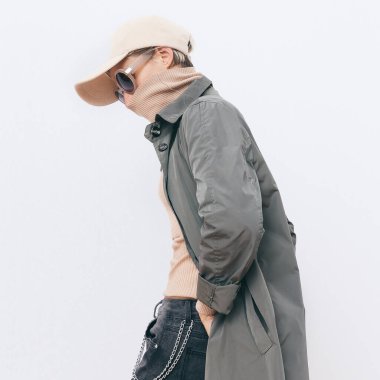 Moda sokak kıyafeti giyen bir kız. Moda şapkası ve askeri ceket. Şık Sonbahar kış mevsimleri. Sıradan görünüm kitabı