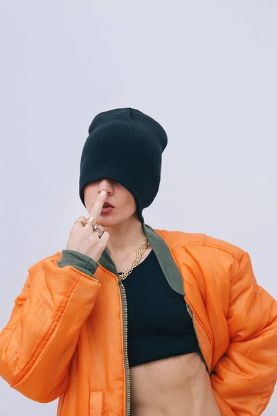 都市女孩在时尚街上的样子 时髦的橙色炸弹夹克和时髦的贝尼帽 中指挑衅秋季冬季观景册 — 图库照片
