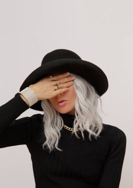 Şehvetli manken gündelik sonbahar kış kıyafetleri giyiyor. Moda minimalist tarzı. Her günkü zarif görünüşün ayrıntıları. Moda aksesuar siyah şapka ve mücevherler