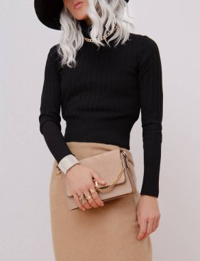 Gündelik sonbahar kış kıyafetleri giymiş bir manken. Moda minimalist tarzı. Günlük bakışın ayrıntıları. Modaya uygun bir şapka, mücevher ve çanta.