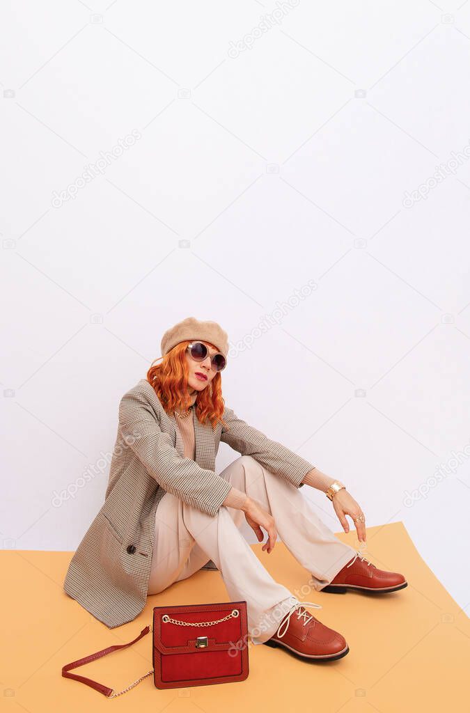 Paris Girl in fashion elegant retro outfit. Trendy beige beret, sunglasses and stylish plaid blazer and trousers. Beige total look. Style in details. Fall winter season. Vintage lover