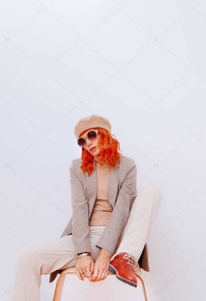 Stylish Paris Lady in fashion elegant outfit. Trendy beige beret, sunglasses and stylish plaid blazer and trousers. Beige total look. Style in details. Fall winter season. Vintage lover