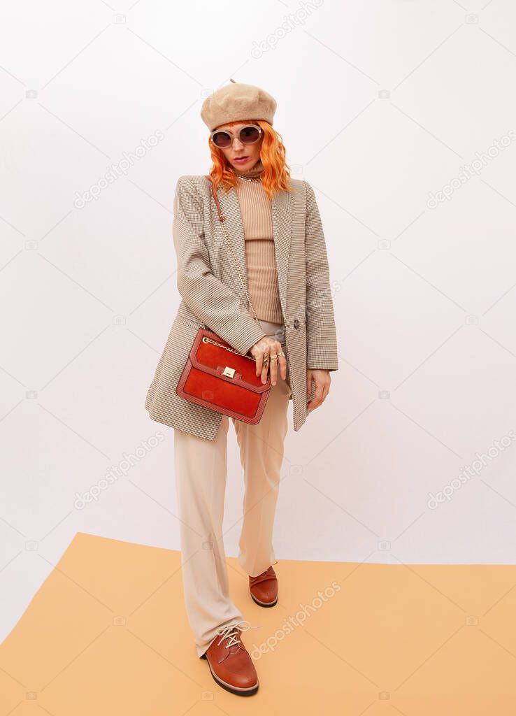 Paris Lady in fashion elegant retro outfit. Trendy beige beret, sunglasses and stylish plaid blazer and trousers. Beige total look. Style in details. Fall winter season. Vintage lover