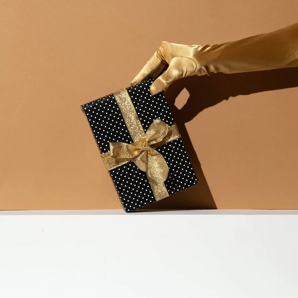 Hand Golden Gloves Holding Gift Box Minimal Still Life Design — Stock Photo, Image