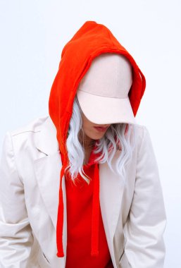 Stüdyodaki sarışın kız. Kırmızı kapüşonlu, modaya uygun bir kış kıyafeti. Kaptan, Denim Takım Elbise. Sokak stili. Moda arama kitabı konsepti