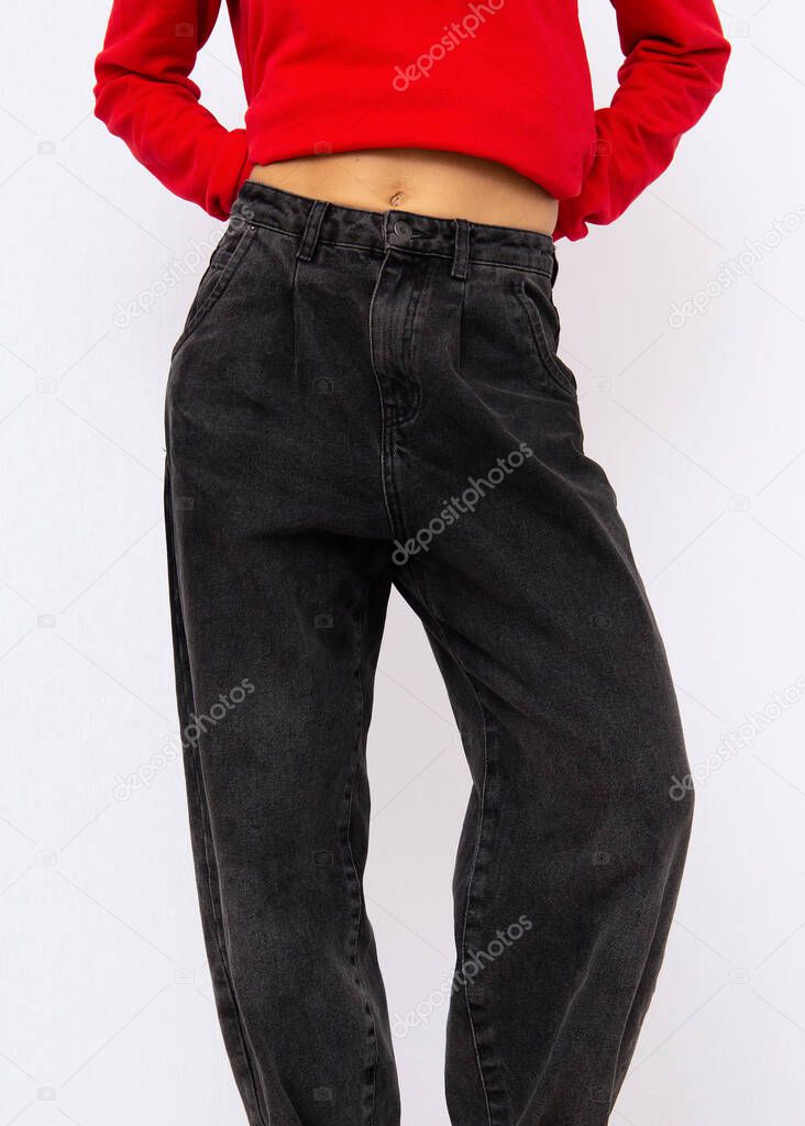 Model in studio. Trendy fall winter casual outfit with red hoodie details. Black boyfriend jeans. Street Style. Fashion lookbook concept
