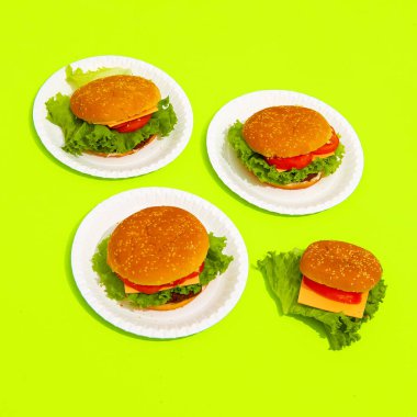 Sarı arka planda fast food burgeri. Hurda gıda Yaratıcı kavram izometrik asgari sanat