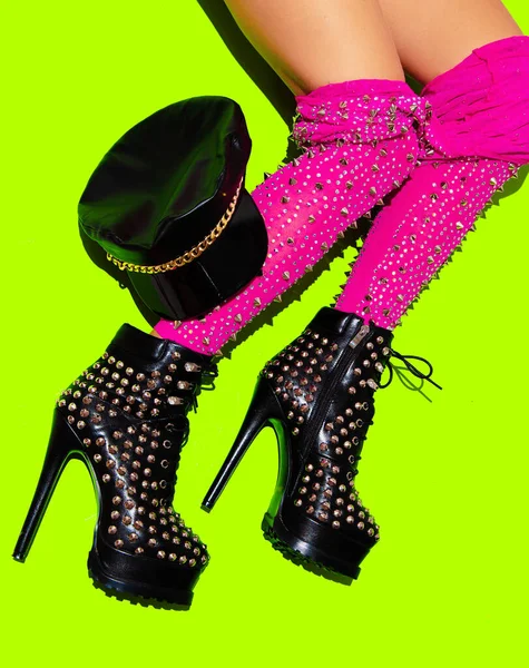 Fashion sexy Lady in heel party boots and leggins down on green minimal background. Stylish clubbing mood.  Go-go Girls. Cabaret. After party adult concept