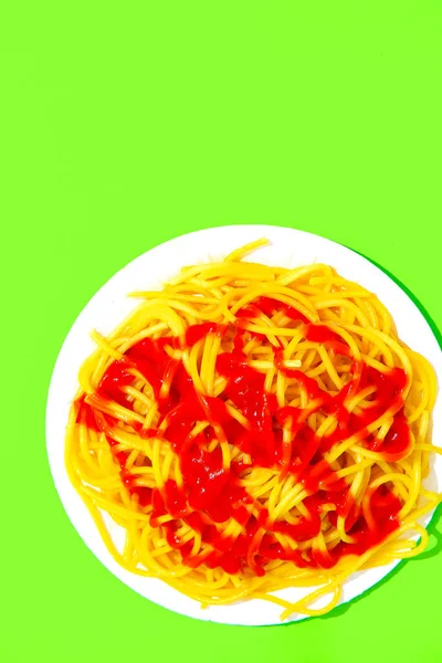 緑の背景にケチャップでスパゲティパスタ ミニマリスト カロリー Italian Food Art Concept — ストック写真