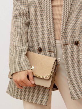Şık bir Paris modeli. Günlük bakışın ayrıntıları. Günlük bej renkli damalı ceket ve aksesuar çantası. Moda Minimalist tarzı. Moda güz mevsimi ilkbaharı Bak kitabı.