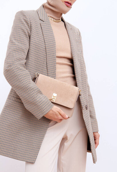 Stylish paris model. Details of everyday look. Casual beige checkered jacket and accessories bag and chain.Trendy Minimalistic style. Fashion fall winter spring look book.