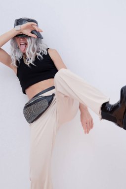 Şık yaz kıyafetleri içinde oyuncu kadın moda portresi. Kova şapka, debriyaj ve mücevher. Mimalist eğilimler.