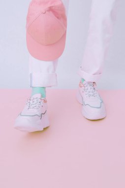 Modayı takip eden yaz kıyafetlerinin ayrıntıları. Stüdyoda beyaz kot pantolon ve şık ayakkabılar giyen bir kız. Her gün bak. Sokak modası konsepti. Yüzü yok. Minimalist pastel renkler estetik.