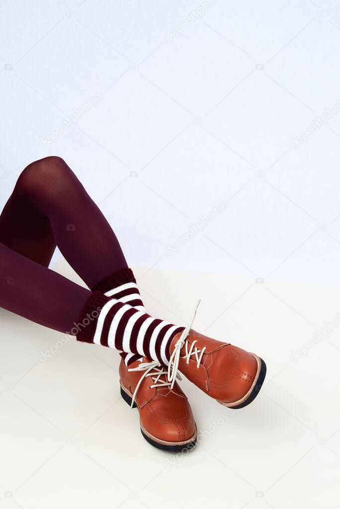 Shoot of unrecognizable woman wearing retro brown shoes and stripped socks. Fashion vintage shop concept