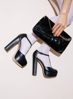 Beyaz taytlı, siyah ayakkabılı, tanınmayan bir manken. Minimalist zarif debriyaj. Paris düz yatış stilini detaylandırıyor. Retro estetik..