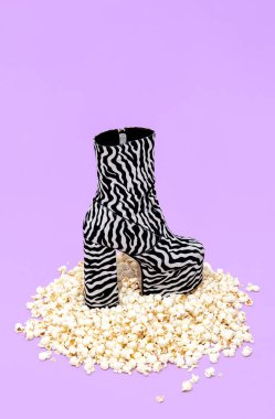 Minimum patlamış mısır arka planı ve moda zebra botları. Hala hayat tasarımı. Moda ev sineması konsepti