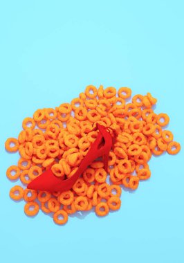 Minimum mısır halkaları arka plan ve moda bayan kırmızı ayakkabılar. Moda natürmort dikey tasarım. Diyet, fast food, kalori, sağlıksız gıda konsepti.