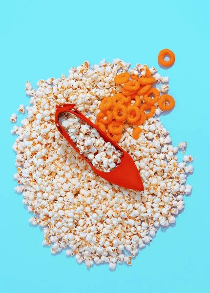 Minimal popcorn, corn rings background and fashion lady shoes. Still life vertical design.  Diet, fast food, calory, unhealthy food concept.