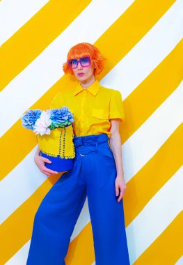 Fashion Retro Lady sarı çizgili arka planda elinde çiçek aranjmanıyla. Minimum bahar yaz konsepti