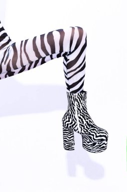 Garip, şık zebra desenli, beyaz bir stüdyoda poz veren genç bir çift cinsiyetli model. Kulüp parti tarzı
