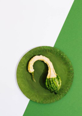 Taze minimalist sahne. Yeşil tabakta organik balkabağı ve kağıt geometri arka planı. Sıfır atık, biyoloji, çevre, vegan konsept. Kaliteli düz duvar kağıdı