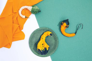 Minimalist taze mevsimlik sahne. Yeşil ve beyaz arka planda organik dekor balkabakları ve tekstil. Sıfır atık, biyolojik pazar, eko, vegan, ham, tasarruf gezegeni konsepti. Gösterişli düz pankart