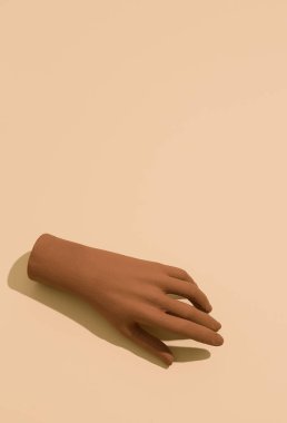 Bej kağıtlı arka planda alçı kahverengi el. Soyut minimal pankart duvar kağıdı