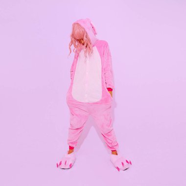 Beyaz stüdyoda poz veren pembe pijamalı parti kızı. Ev Rahatlığı moda tarzı. Kigurumi dükkanı konsepti