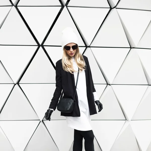 Die glamouröse Blondine steht an der Wand. Urban Fashion schwarz-weiß — Stockfoto