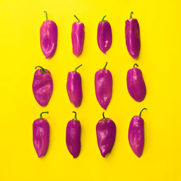 Set of neatly arranged bright peppers on yellow background for use in design — Stock Photo, Image