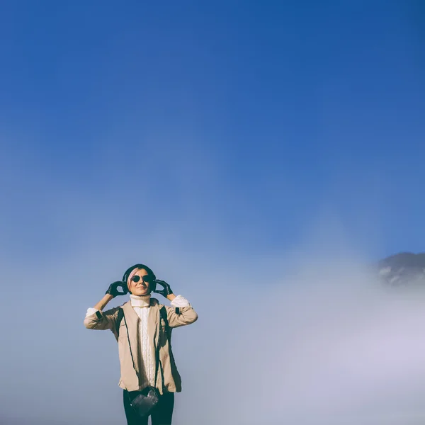 Imagen de estilo de vida. Chica en la niebla escuchando música y disfrutando de la naturaleza . —  Fotos de Stock